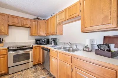 a kitchen with wooden cabinets and a sink at Boulder Brook on Fall River in Estes Park