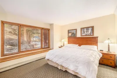 a bedroom with a large bed and a window at Boulder Brook on Fall River in Estes Park