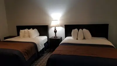 a hotel room with two beds and a lamp at Valley Hi Hotel in Winter Park