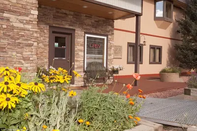 a garden with flowers in front of a building at Valley Hi Hotel in Winter Park