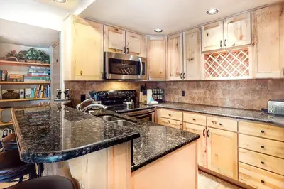 a kitchen with wooden cabinets and a black counter top at Wild I rishman 1003 in Keystone