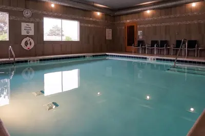 a large swimming pool with blue water in a room at Holiday Inn Express & Suites - Aurora Medical Campus by IHG in Aurora