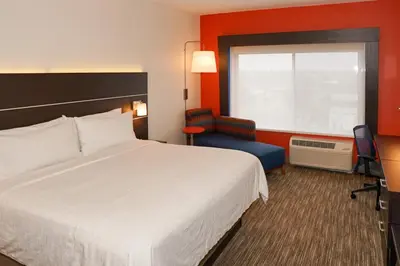 a hotel room with a bed and a chair and a window at Holiday Inn Express & Suites - Aurora Medical Campus by IHG in Aurora