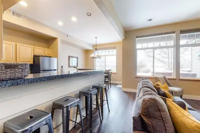 a kitchen with a bar with stools and a couch at Silverthorne Sanctuary in Silverthorne