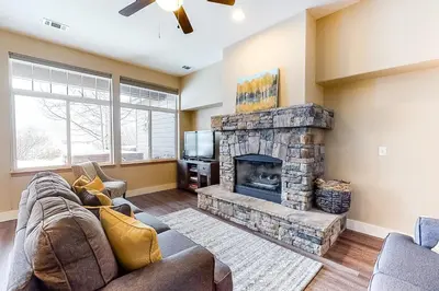 a living room with a stone fireplace and a tv at Silverthorne Sanctuary in Silverthorne