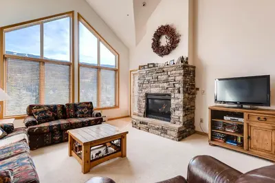 a living room with a fireplace and a television at Gateway 5039 in Keystone