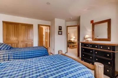 a bedroom with two beds and a dresser and a mirror at Gateway 5039 in Keystone