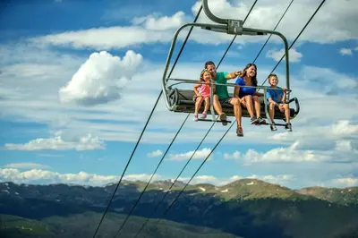 a group of people sitting on a ski lift at Gateway 5039 in Keystone