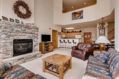 a living room with a stone fireplace and couches at Gateway 5039 in Keystone