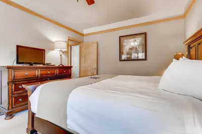 a bedroom with a bed and a dresser with a television at Chateaux DuMont 2724 in Keystone