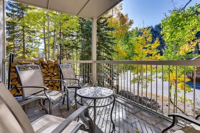 a porch with chairs and a table with a view of trees at Chateaux DuMont 2724 in Keystone