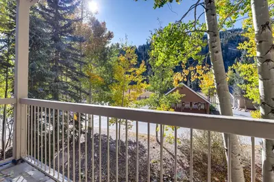 a balcony with a view of a house and trees at Chateaux DuMont 2724 in Keystone