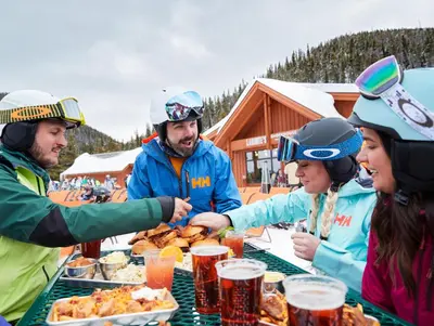 a group of people sitting around a table eating food at Chateaux DuMont 2724 in Keystone