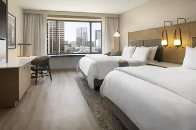 a hotel room with two beds and a desk at The Westin Denver Downtown in Denver