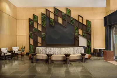 a lobby with a bench and tables and chairs at The Westin Denver Downtown in Denver