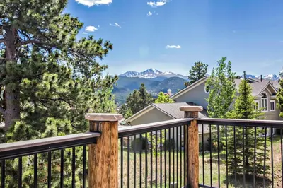 a wooden fence with mountains in the background at The Stanley Hotel in Estes Park