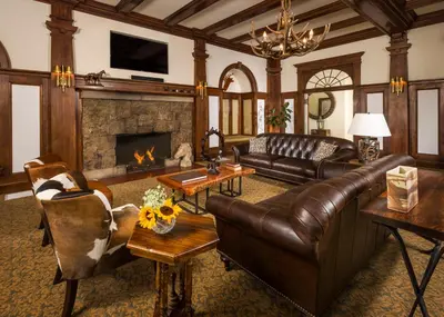 a living room with leather furniture and a fireplace at The Stanley Hotel in Estes Park