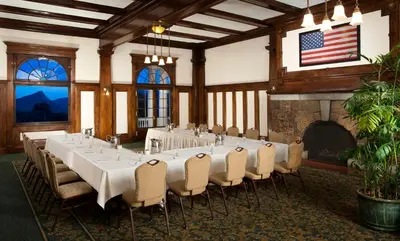 a room with a long table and chairs and a fireplace at The Stanley Hotel in Estes Park