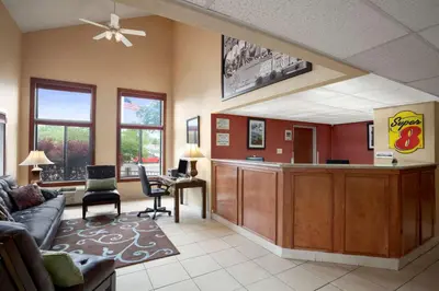 a living room with a waiting area with a bar at Super 8 by Wyndham Westminster Denver North in Westminster