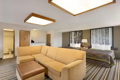 a living room with a couch and a bed at Super 8 by Wyndham Westminster Denver North in Westminster