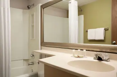 a bathroom with a sink and a mirror at Super 8 by Wyndham Westminster Denver North in Westminster