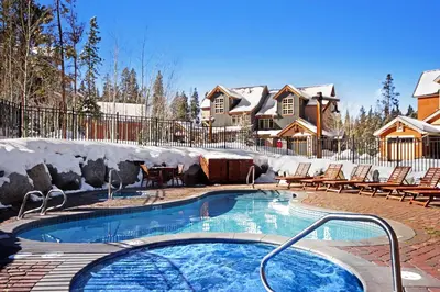 a swimming pool in a yard with chairs and a house at 6508 Settlers Creek Townhomes in Keystone