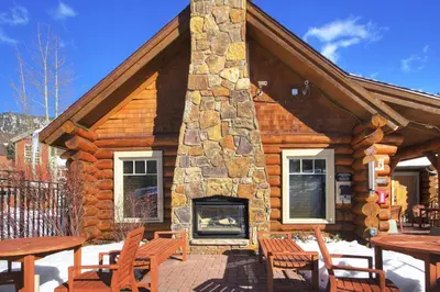 a log cabin with a fireplace on a patio at 6508 Settlers Creek Townhomes in Keystone