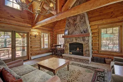 a living room with a fireplace in a log cabin at 6508 Settlers Creek Townhomes in Keystone