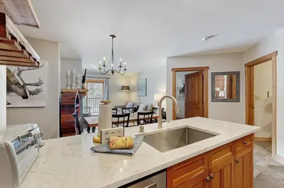 a kitchen with a sink and a living room at Red Hawk Lodge 2254 in Keystone