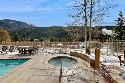 a swimming pool with a table and chairs in the snow at Red Hawk Lodge 2254 in Keystone