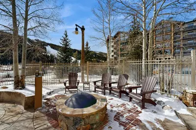 a patio with chairs and a fire pit in the snow at Red Hawk Lodge 2254 in Keystone