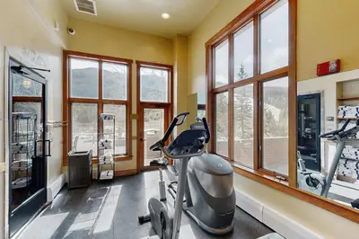 a gym with a treadmill in a room with windows at Red Hawk Lodge 2254 in Keystone