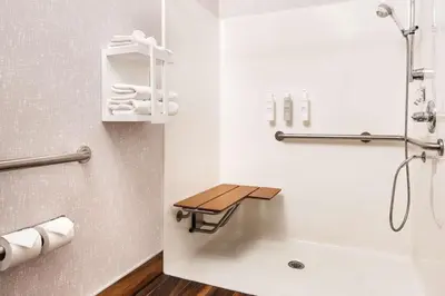 a bathroom with a shower and a toilet and a sink at Hampton Inn Longmont in Longmont
