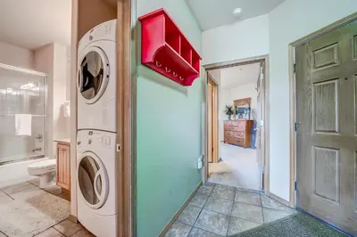 a laundry room with a washer and dryer next to a door at Tarn Landing C-19 Condo in Frisco
