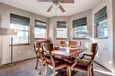 a dining room with a table and chairs and windows at Tarn Landing C-19 Condo in Frisco