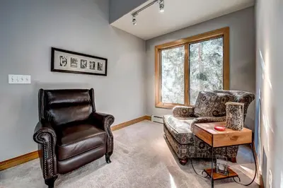 a living room with a leather chair and a chair and a table at Streamside 333B Townhouse in Frisco
