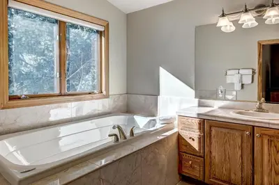 a bathroom with a tub and a sink and a mirror at Streamside 333B Townhouse in Frisco