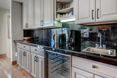 a kitchen with white cabinets and a black counter top at Streamside 333B Townhouse in Frisco