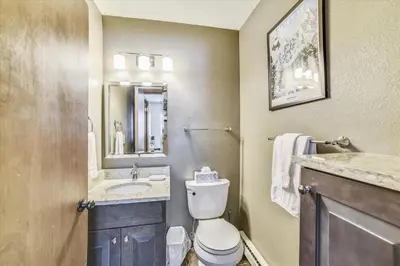 a bathroom with a toilet and a sink and a mirror at Forest Park F Condo in Frisco
