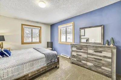 a bedroom with a bed and a dresser with a mirror at Forest Park F Condo in Frisco