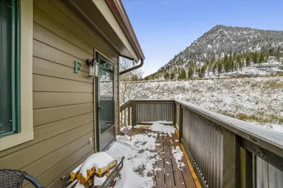 a balcony with a snow covered bench next to a house at Forest Park F Condo in Frisco