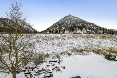 a snow covered field with a mountain in the background at Forest Park F Condo in Frisco