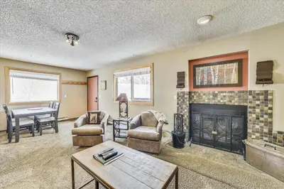 a living room with a fireplace and a table at Forest Park F Condo in Frisco