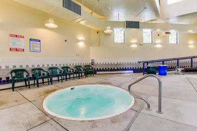 a large tub in a gym with green chairs at Treehouse 202 in Silverthorne