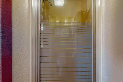 a hallway with a walk in shower with blinds at Treehouse 202 in Silverthorne