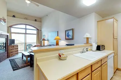 a kitchen with a sink and a living room at Dillon Commons Studio in Dillon
