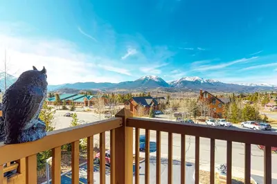 a teddy bear sitting on a balcony looking at the mountains at Dillon Commons Studio in Dillon