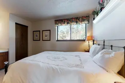 a bedroom with a large white bed with a window at Buffalo Ridge 205 in Silverthorne