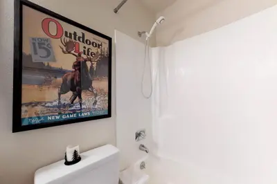 a bathroom with a poster of a moose on the wall at Buffalo Ridge 205 in Silverthorne
