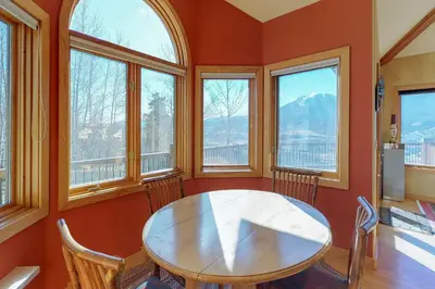 a dining room with a table and some windows at Aspen View in Silverthorne